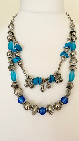 Stay on trend with this double strand necklace in stunning marine blue, aqua, and silver shades, omplete with a lobster claw clasp and extension chain for an adjustable fit. Elevate your outfit with this stylish and versatile accessory.