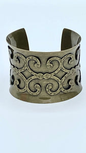 This burnished bronze colour cuff bracelet effortlessly slips onto your wrist, providing a stylish and versatile accessory to any outfit. With a diameter of approximately 7cm and a height of 5.5cm, enhance your style with this timeless piece.