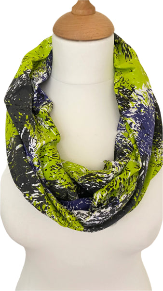 abstract design infinity scarf. The vibrant colours of lime green, lilac, black, and white combine to create a stunning pattern, while the soft and crease resistant fabric makes for a hassle free wearing experience