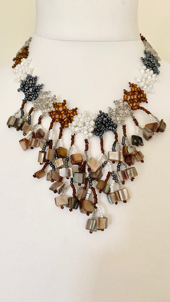 Enhance your wardrobe with this super stylish necklace, featuring neutral shades that have an iridescent finish, closure is a bobble and hoop fastening. A chic and versatile accessory will add a modern touch to your outfits.